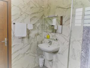 a marble bathroom with a sink and a shower at Les Residences de la Diaspora in Dakar