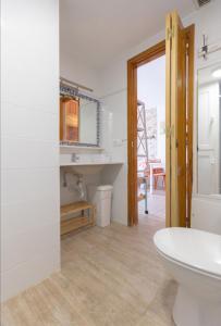 ein Badezimmer mit einem weißen Waschbecken und einem WC in der Unterkunft Apartamento Nire Lula en la misma playa in Cotillo
