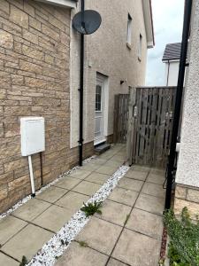 a side walk with a fence and a house at Modern Comfy One Bed Apartment - Free Parking in Glasgow