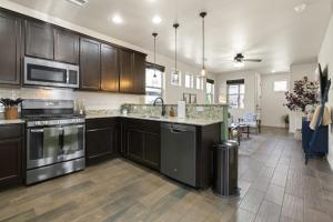 a kitchen with stainless steel appliances and a living room at The Sage Wood House in Flagstaff