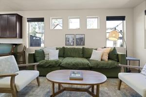 a living room with a green couch and a table at The Sage Wood House in Flagstaff
