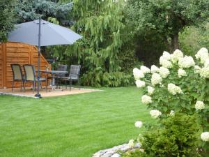 a garden with a table and chairs and an umbrella at Ferienhaus zwischen den Seen in Sedlitz