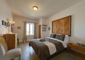 ein Schlafzimmer mit einem großen Bett und einem Stuhl in der Unterkunft Maison Zacharie in Desbiens
