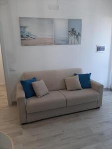 a couch with two blue pillows in a living room at Ca San Vito Lo Capo Villa Maria in San Vito lo Capo