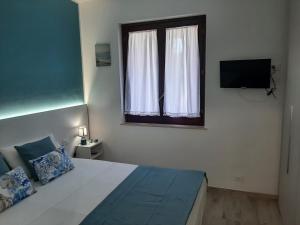 a bedroom with a bed with a window and a television at Ca San Vito Lo Capo Villa Maria in San Vito lo Capo