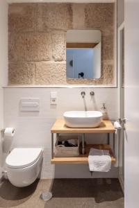 bagno con lavandino, servizi igienici e specchio di La Fonda a Pontevedra