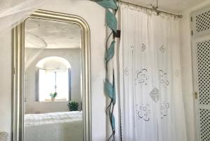 a mirror in a bathroom with a white shower curtain at CASA DEL TEATRO Luxury Casas Vejer Debra in Vejer de la Frontera