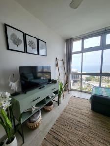 sala de estar con TV y ventana grande en KimOcean La Ballito Apartment, en Ballito