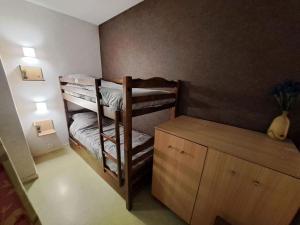 Cette petite chambre comprend des lits superposés et un bureau. dans l'établissement Charmant appartement dans résidence neuve - 5 places, à Nérac