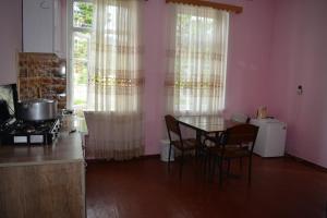 a kitchen with a table and chairs and a window at Giga Guest House in Makhinjauri