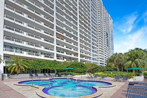 une piscine en face d'un grand bâtiment dans l'établissement Only in My Dreams! Direct Water View Luxury Condo, à Miami
