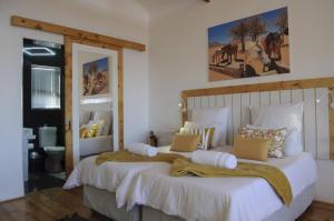 een slaapkamer met een groot bed met witte lakens en kussens bij Wildhorses B&B and Self Catering in Lüderitz