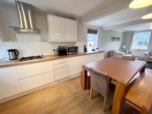 a kitchen with white cabinets and a wooden table at Pex Residence: 5-Bedroom Home in Hook in Hook