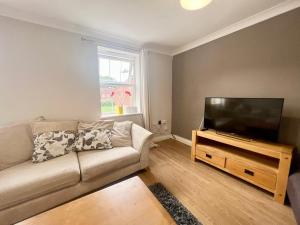 uma sala de estar com um sofá e uma televisão de ecrã plano em Pex Residence: 5-Bedroom Home in Hook em Hook