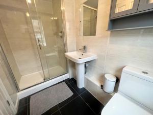 a bathroom with a sink and a shower and a toilet at Pex Residence: 5-Bedroom Home in Hook in Hook