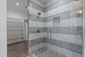 La salle de bains est pourvue d'une douche avec une porte en verre. dans l'établissement NEW Mini Mansion Paradise Hot Tub Pool table 2 acres AC, à Flagstaff