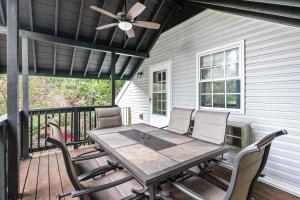 einen Tisch und Stühle auf einer Veranda mit Deckenventilator in der Unterkunft Memories On Madison Entire Home With Game Room 16 in Clarksville