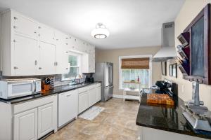 uma cozinha com armários brancos e bancadas pretas em Madison Terrace - Large Home With Game Room - 10 em Clarksville