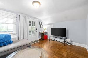 a living room with a couch and a flat screen tv at The Loft At Madison Terrace - Private Unit in Clarksville