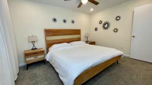 a bedroom with a large white bed and a nightstand at The Blue Door at Sylva Home Base Apartments in Sylva