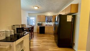 a kitchen with a black refrigerator and a table at The Blue Door at Sylva Home Base Apartments in Sylva