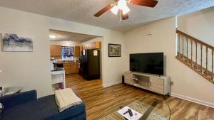 a living room with a couch and a flat screen tv at The Blue Door at Sylva Home Base Apartments in Sylva