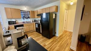 a kitchen with a black refrigerator and wooden floors at The Blue Door at Sylva Home Base Apartments in Sylva +18 photos