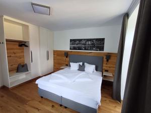 Schlafzimmer mit einem großen weißen Bett und Holzböden in der Unterkunft Appartements-Strandschlößl Heitzmann in Seeboden