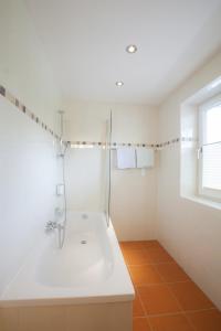 a white bathroom with a shower and a sink at Hotel Silvia in Sankt Kanzian