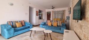- un salon avec deux canapés bleus et une table dans l'établissement Pearl Beach Lifestyle, à Mombasa