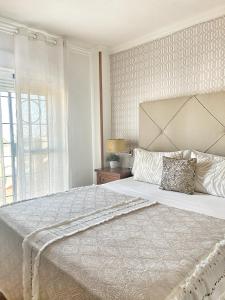 Un dormitorio blanco con una cama grande y una ventana en Luxury Sunny Villa, en Málaga