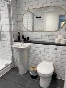 a bathroom with a sink and a toilet and a mirror at Hotel Tia in Liverpool