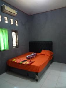 - une chambre avec un lit et une couette en orange dans l'établissement Ambasador, à Cipakus