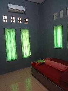- une chambre avec des rideaux verts et un lit dans l'établissement Ambasador, à Cipakus