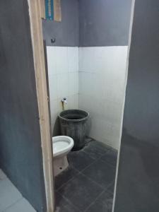 La salle de bains est pourvue de toilettes et d'un seau. dans l'établissement Ambasador, à Cipakus