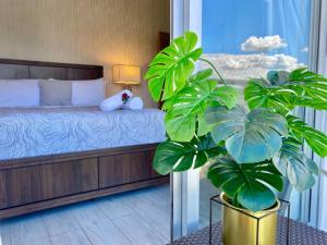 um quarto com uma cama e um vaso de plantas em Cozy City Center Condo Pool em Los Prados