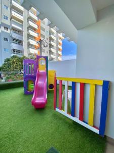 um parque infantil com escorrega numa sala em Cozy City Center Condo Pool em Los Prados