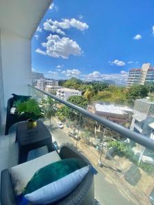 uma varanda com um sofá e vista para a cidade em Cozy City Center Condo Pool em Los Prados