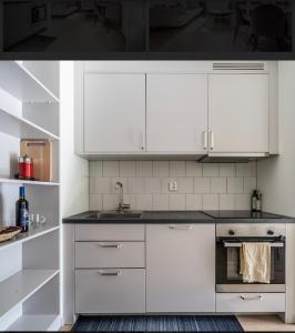 una cocina blanca con armarios blancos y fregadero en Central apartment 5min drive to the Airport., en Estocolmo