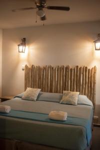 a bedroom with a large bed with a wooden headboard at Aquamare Bungalows in Cruz de Pizarro