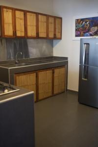 a kitchen with a stainless steel refrigerator and wooden cabinets at Aquamare Bungalows in Cruz de Pizarro