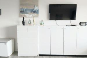 a white cabinet with a television on top of it at Studio met zeezicht in Blankenberge