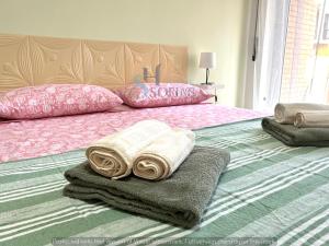 a bed with towels and pillows on top of it at Sofia's Home 2 in Terracina