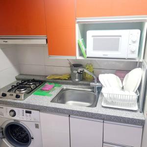 - un comptoir de cuisine avec évier et four micro-ondes dans l'établissement KEVIN HOME 42, à Daegu