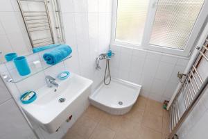 een witte badkamer met een wastafel en een toilet bij My Cozy Place in Boekarest +16 foto's