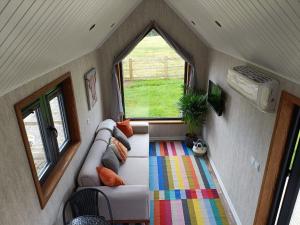 a living room with a couch and a window at The Tiny House in Bovey Tracey