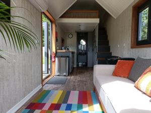 a living room with a couch and a colorful rug at The Tiny House in Bovey Tracey
