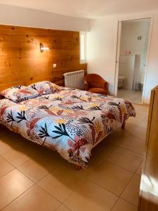 1 dormitorio con 1 cama con un edredón colorido en Appartement indépendant avec jardin et accès piscine, en Nimes