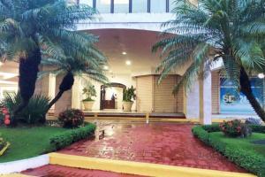 a courtyard with palm trees in a building at Lovely Sto Dgo Center Apt in Santo Domingo