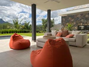 a living room with a couch and orange bean bags at SANTOSHA in Tamarin